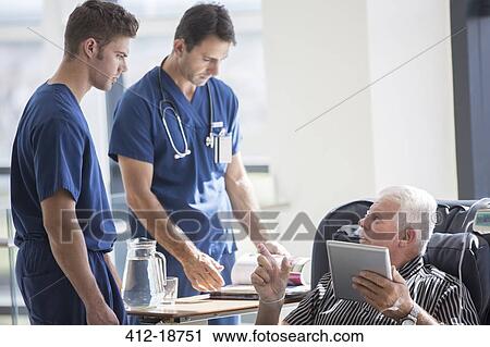 Patient using tablet pc and talking to doctors in hospital View Large Photo Image Stock Image - Patient using tablet pc and talking to doctors in hospital. Fotosearch