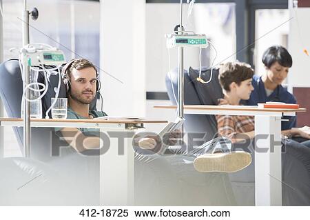 Patients in armchairs receiving medical treatment in hospital ward View Large Photo Image Stock Photography - Patients in armchairs receiving medical treatment in hospital ward. Fotosearch