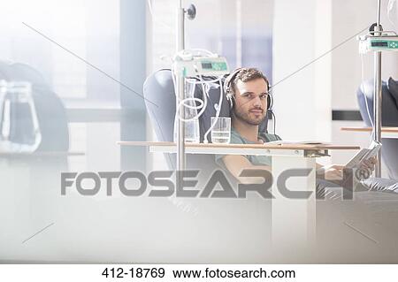 Portrait of man receiving intravenous infusion in hospital View Large Photo Image Stock Photo - Portrait of man receiving intravenous infusion in hospital. Fotosearch