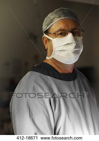 Stock Image - Portrait of mature surgeon by operating theater. Fotosearch