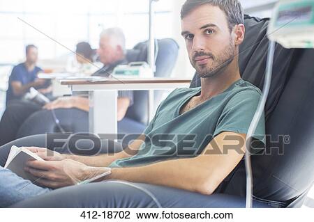Stock Image - Portrait of young patient getting treatment and holding book. Fotosearch