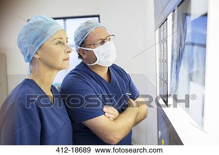 Two doctors discussing patient's x-ray and MRI before surgery View Large Photo Image Stock Photo - Two doctors discussing patient's x-ray and MRI before surgery. Fotosearch