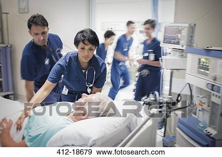 Two doctors preparing elderly patient before medical procedure View Large Photo Image Stock Photo - Two doctors preparing elderly patient before medical procedure. Fotosearch
