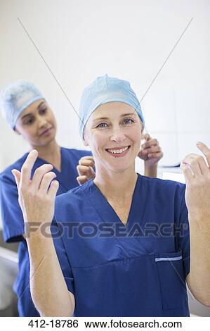 Two female surgeons getting dressed for operation View Large Photo Image Stock Photograph - Two female surgeons getting dressed for operation. Fotosearch