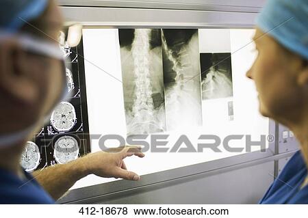 Two mature doctors discussing patient's x-ray and MRI scans View Large Photo Image Stock Photo - Two mature doctors discussing patient's x-ray and MRI scans. Fotosearch