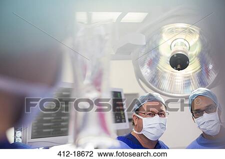 Two surgeons looking at saline bag during surgery View Large Photo Image Stock Image - Two surgeons looking at saline bag during surgery. Fotosearch