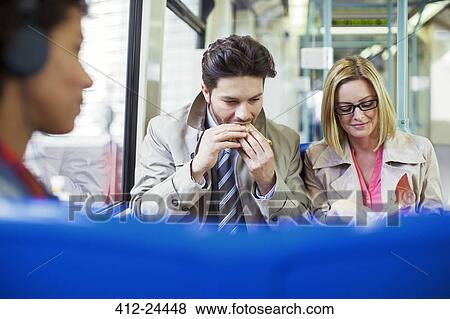 Stock Photo - Business people eating on train. Fotosearch