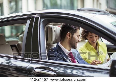Business people reading paperwork in car View Large Photo Image Stock Photo - Business people reading paperwork in car. Fotosearch