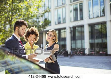 Business people reading paperwork in city View Large Photo Image Stock Photography - Business people reading paperwork in city. Fotosearch