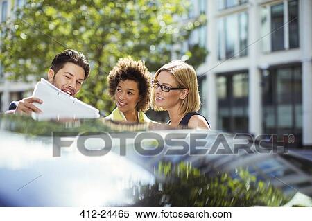 Business people reading paperwork near car View Large Photo Image Stock Photography - Business people reading paperwork near car . Fotosearch