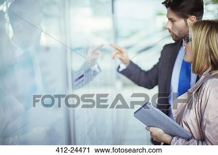 Business people reading transportation schedule at station View Large Photo Image Stock Image - Business people reading transportation schedule at station. Fotosearch