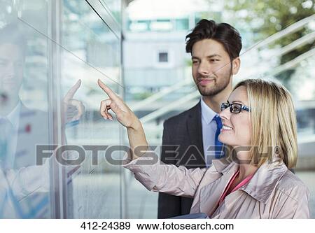 Business people reading transportation schedule View Large Photo Image Stock Photo - Business people reading transportation schedule. Fotosearch