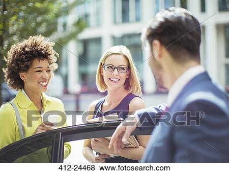 Stock Photo - Business people talking near car. Fotosearch
