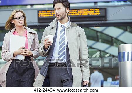 Picture - Business people walking and talking in train station. Fotosearch