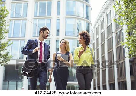 Stock Photo - Business people walking and talking outdoors. Fotosearch