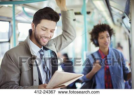 Businessman reading newspaper on train View Large Photo Image Stock Photo - Businessman reading newspaper on train. Fotosearch
