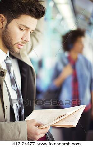 Stock Photo - Businessman reading newspaper on train. Fotosearch