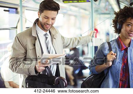 Businessman reading newspaper on train View Large Photo Image Stock Photograph - Businessman reading newspaper on train. Fotosearch