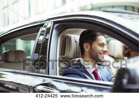 Stock Photography - Businessman smiling in car. Fotosearch