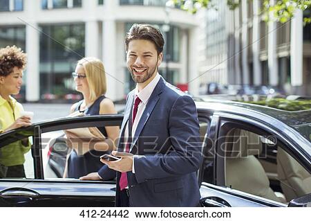 Businessman smiling outside car View Large Photo Image Stock Image - Businessman smiling outside car. Fotosearch