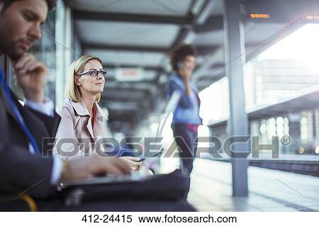 Stock Photography - Businessman using laptop in train station. Fotosearch