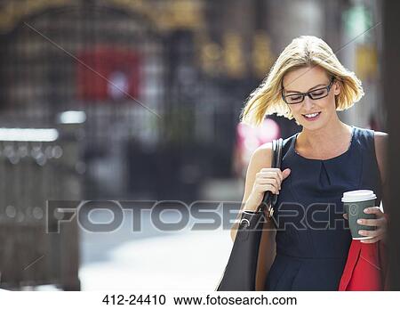 Businesswoman carrying cup of coffee in city View Large Photo Image Stock Image - Businesswoman carrying cup of coffee in city. Fotosearch