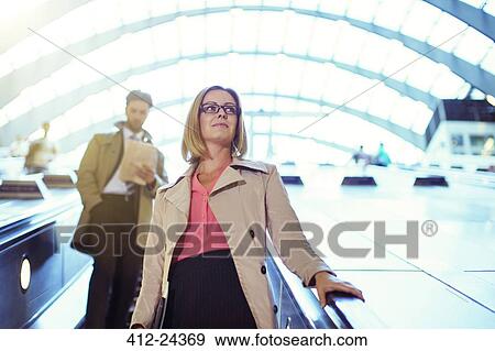 Businesswoman riding escalator View Large Photo Image Stock Photo - Businesswoman riding escalator. Fotosearch