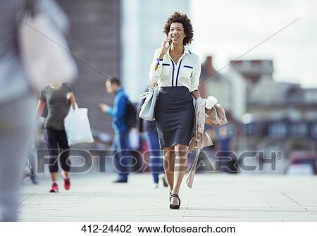 Businesswoman talking on cell phone in city View Large Photo Image Stock Image - Businesswoman talking on cell phone in city. Fotosearch