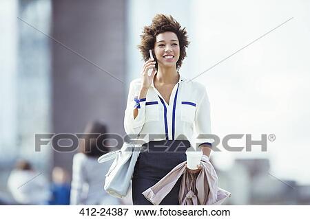 Businesswoman talking on cell phone in city View Large Photo Image Stock Photo - Businesswoman talking on cell phone in city. Fotosearch