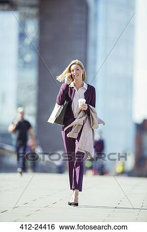 Businesswoman talking on cell phone in city View Large Photo Image Stock Photograph - Businesswoman talking on cell phone in city. Fotosearch