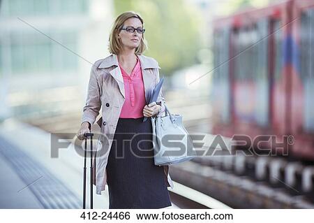 Stock Photograph - Businesswoman waiting at train station. Fotosearch