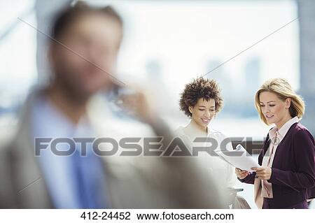 Businesswomen talking at urban waterfront View Large Photo Image Stock Image - Businesswomen talking at urban waterfront. Fotosearch