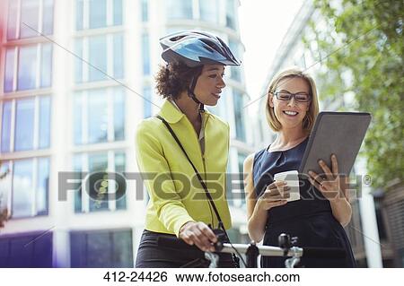Stock Photograph - Businesswomen using digital tablet outdoors. Fotosearch