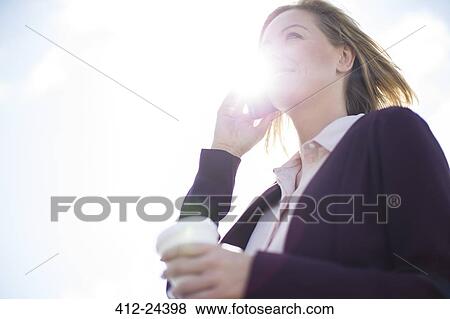 Low angle view of businesswoman talking on cell phone View Large Photo Image Stock Photo - Low angle view of businesswoman talking on cell phone. Fotosearch