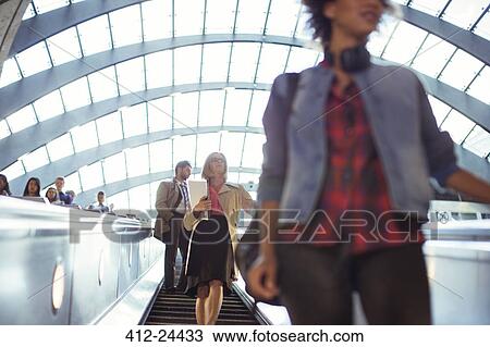 People riding escalator View Large Photo Image Stock Image - People riding escalator. Fotosearch