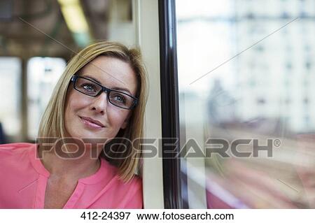 Smiling woman looking out train window View Large Photo Image Stock Photo - Smiling woman looking out train window. Fotosearch