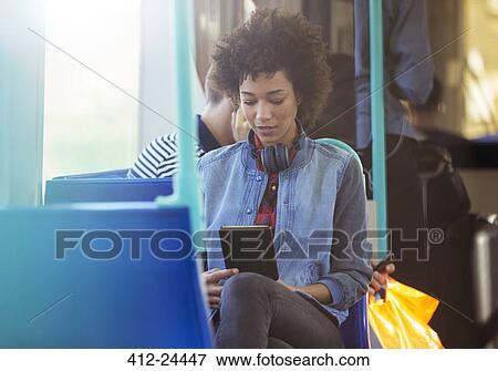 Woman using digital tablet on train View Large Photo Image Stock Photo - Woman using digital tablet on train. Fotosearch