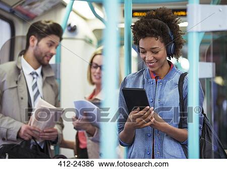 Woman using digital tablet on train View Large Photo Image Stock Photograph - Woman using digital tablet on train. Fotosearch