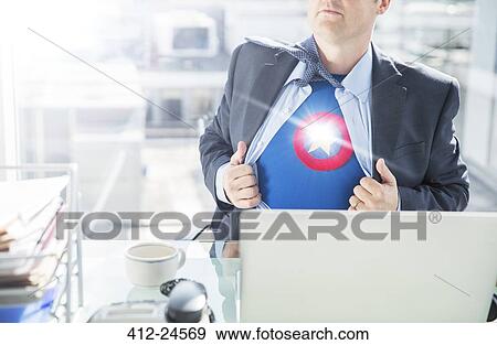 Stock Photo - Businessman opening shirt to reveal superhero costume. Fotosearch