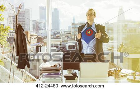 Stock Image - Businessman revealing superhero costume under suit. Fotosearch
