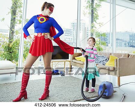 Daughter of superhero vacuuming her cape in living room View Large Photo Image Stock Photograph - Daughter of superhero vacuuming her cape in living room. Fotosearch