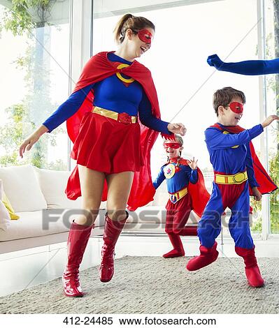 Stock Photography - Family of superheroes playing in living room. Fotosearch