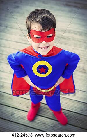 Stock Image - High angle view of superhero boy with hands on hips. Fotosearch