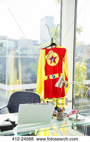 Superhero costume hanging in business office View Large Photo Image Stock Photo - Superhero costume hanging in business office. Fotosearch
