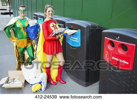 Stock Photo - Superhero couple recycling on city sidewalk. Fotosearch