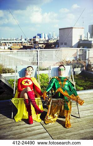 Superhero couple sitting on city rooftop View Large Photo Image Stock Image - Superhero couple sitting on city rooftop. Fotosearch