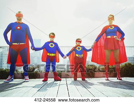 Stock Photo - Superhero family holding hands on city rooftop. Fotosearch