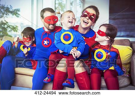 Picture - Superhero family laughing on sofa. Fotosearch