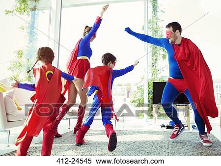 Stock Photography - Superhero family playing in living room. Fotosearch