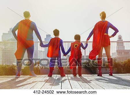 Superhero family standing on city rooftop View Large Photo Image Stock Image - Superhero family standing on city rooftop. Fotosearch
